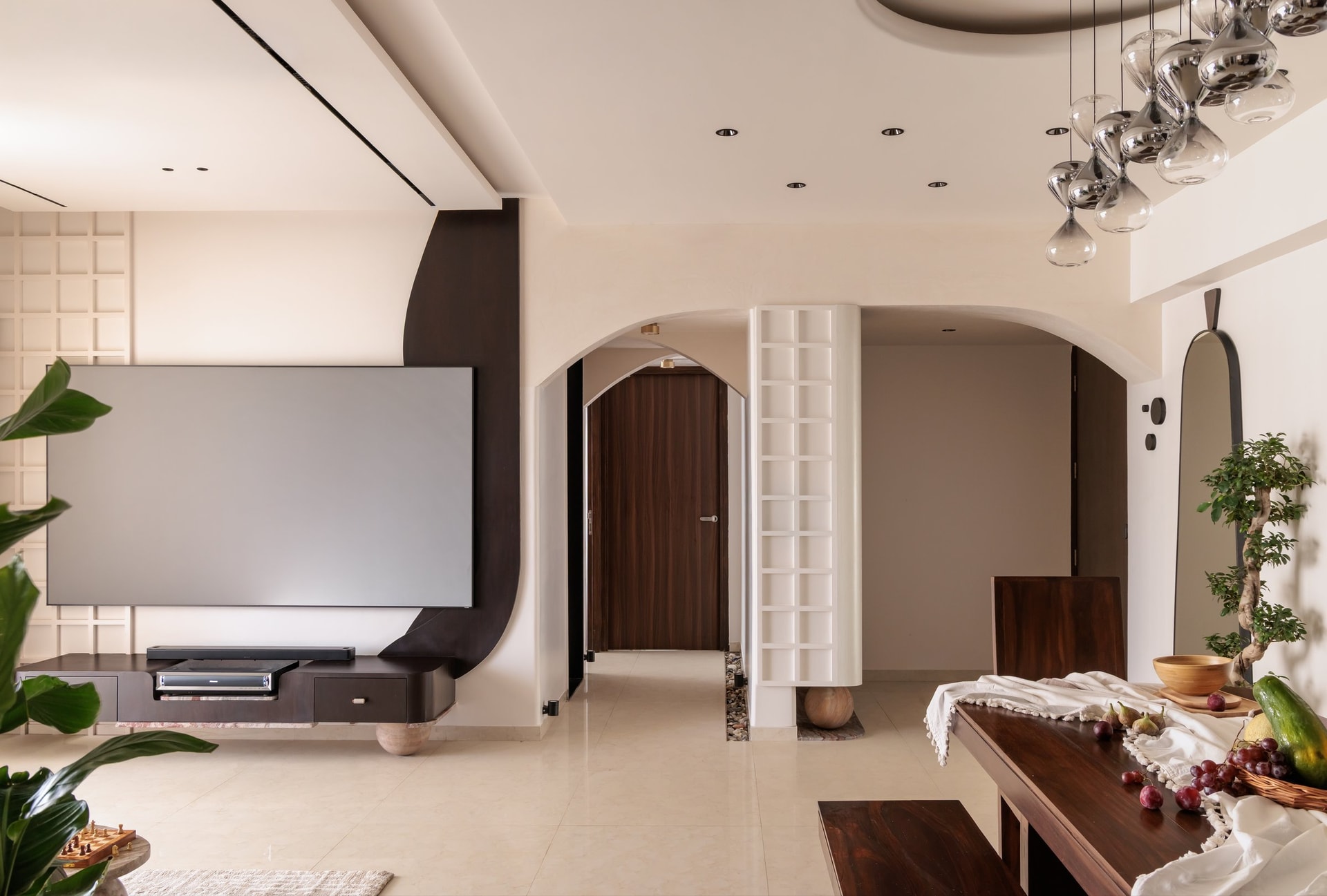 The living area, framed by a sweeping ceiling arch and an arched passage to the private wing