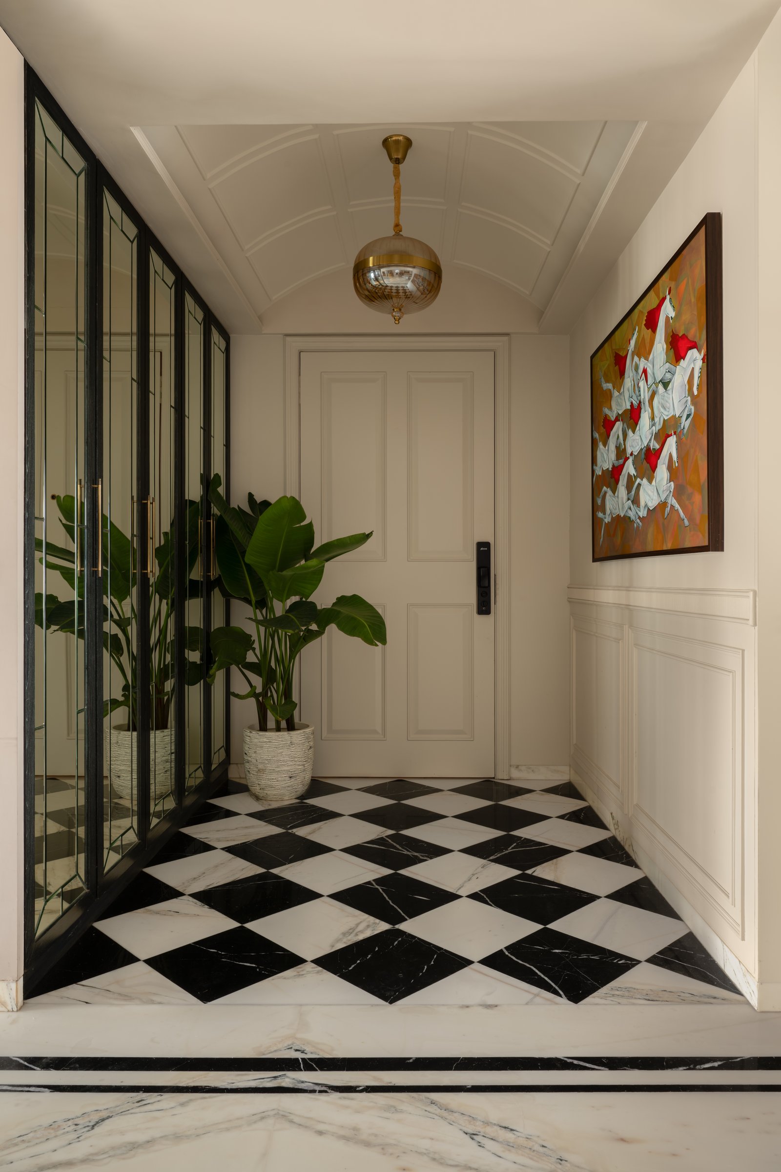 The foyer, where a checkered marble floor and shallow vaulted ceiling establish the home's architectural grammar