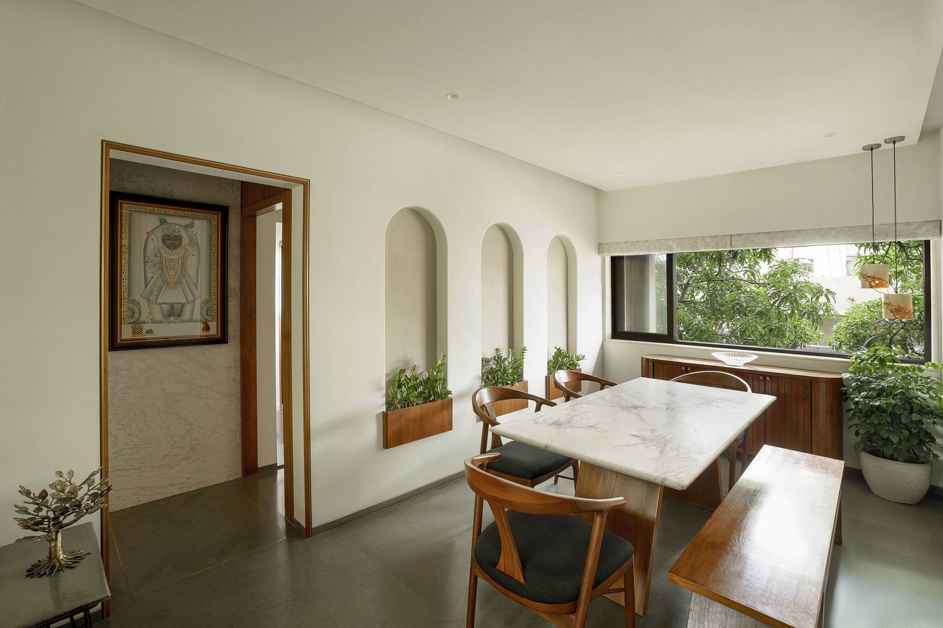 The dining area, where three arched niches hold living planters that draw the outside in