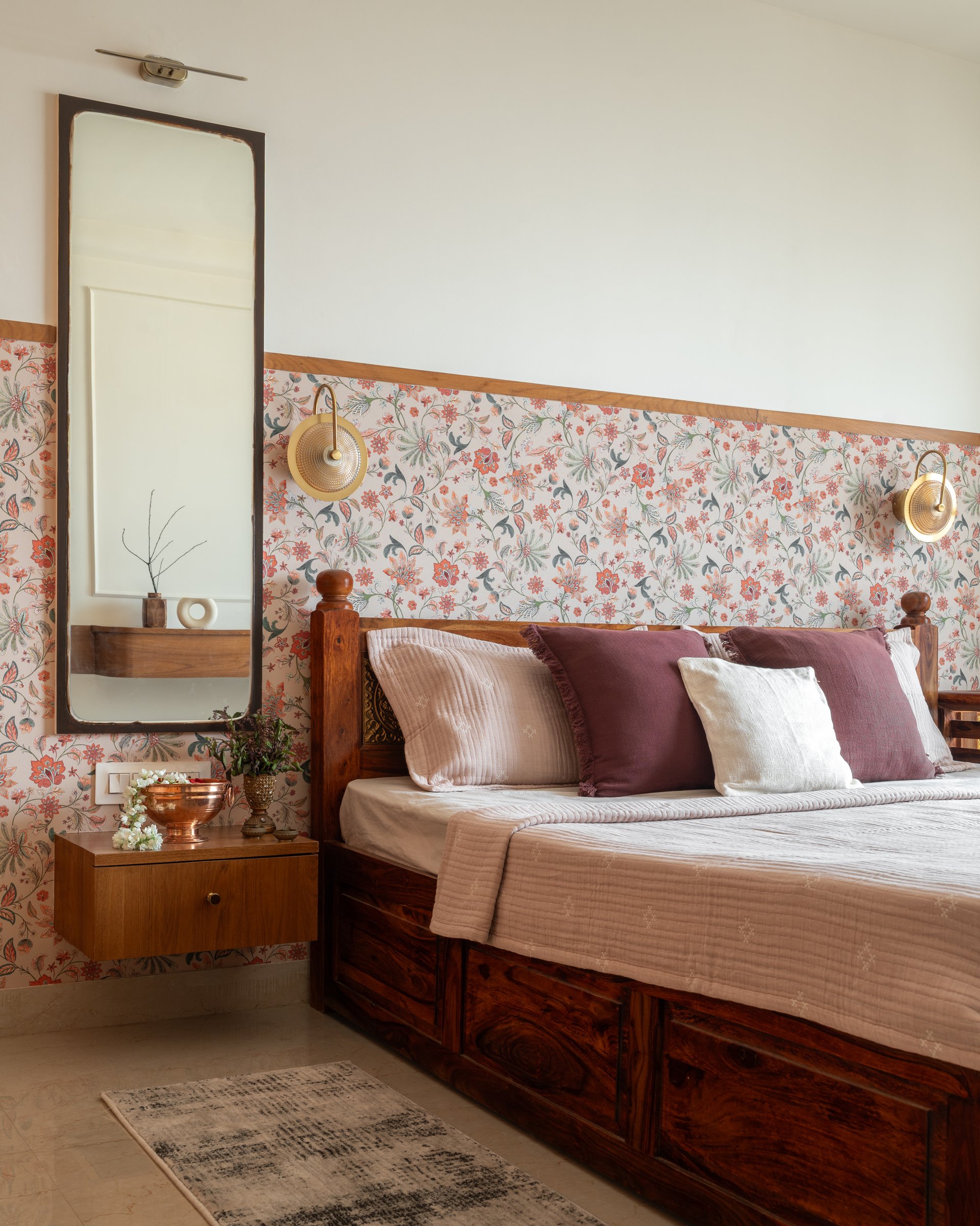 The guest bedroom, where a carved sheesham bed sits against a floral wallpapered dado