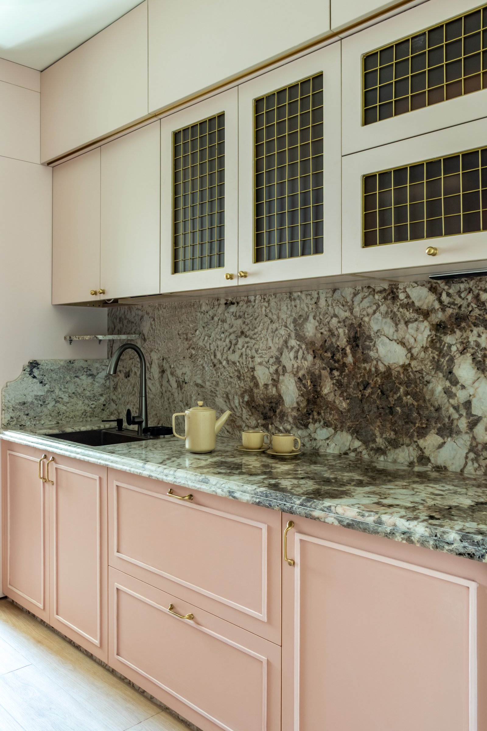 The second run of kitchen cabinetry, with brass-latticed uppers threading a warm metallic note through the room
