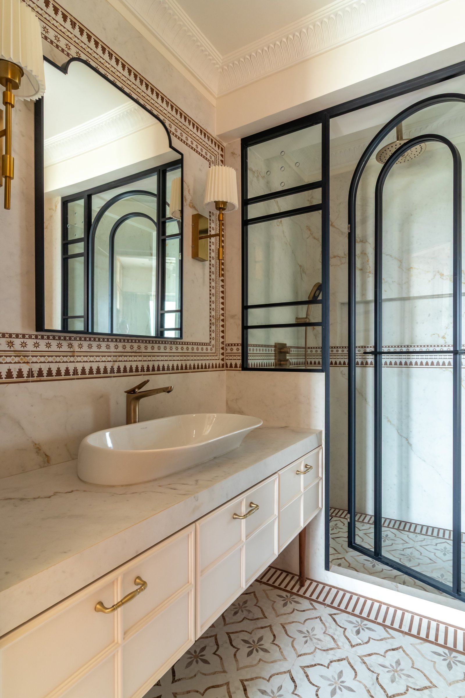 The master bathroom, where pale veined marble meets a Moorish-inspired decorative border