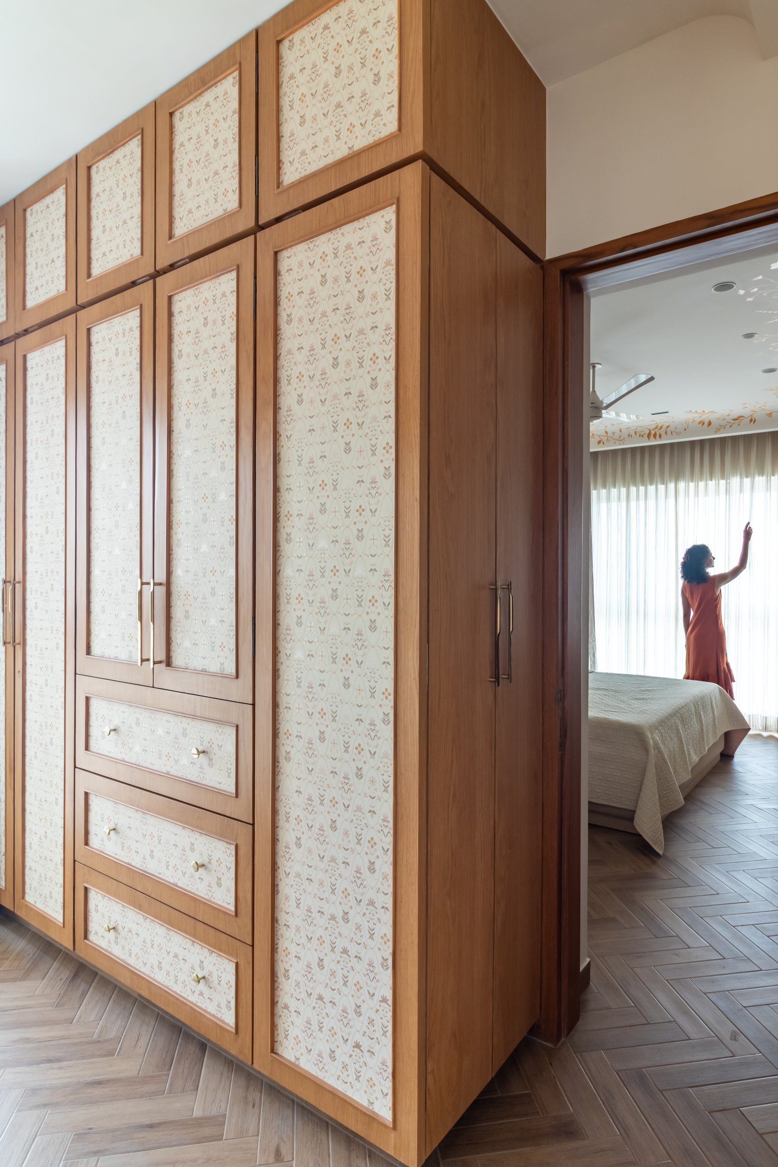 The walk-in wardrobe, its front panels inset with a delicate folk-print in soft rust and ochre