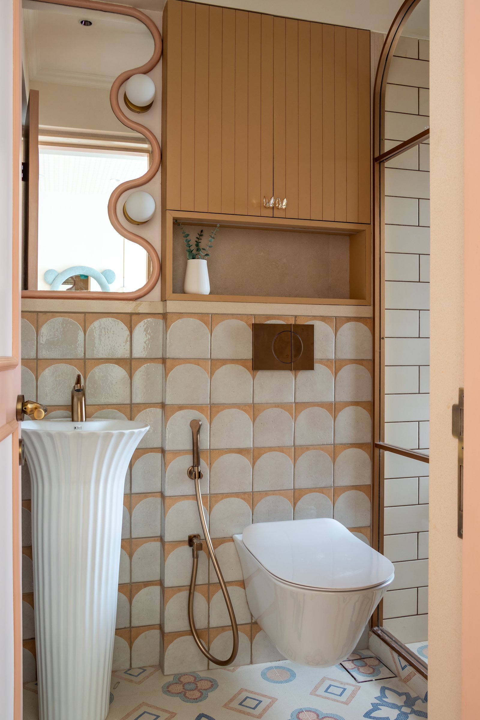 The children's bathroom, where scalloped cream-and-terracotta tiles form a graphic backdrop