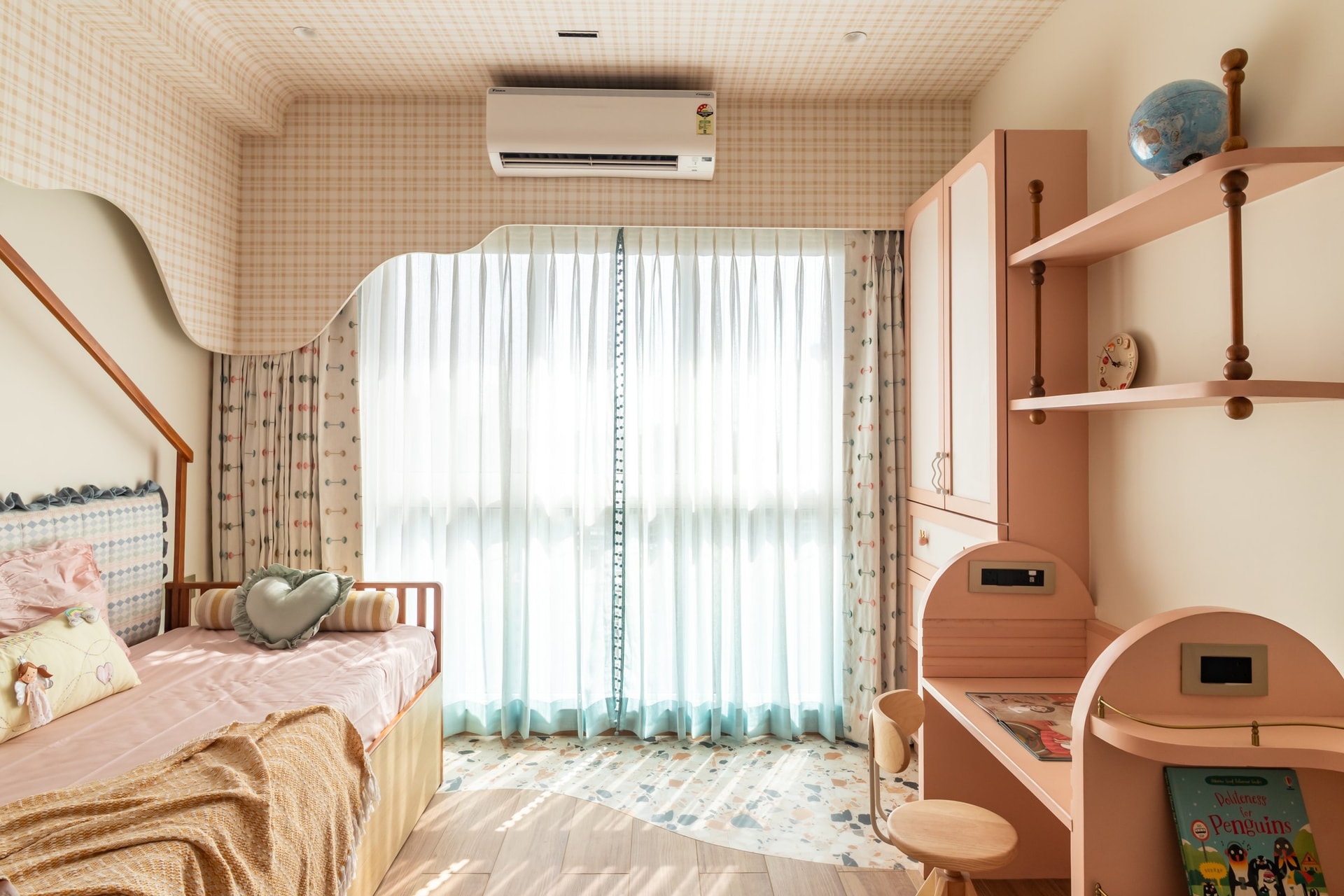 The room extends into a full-height window and a terrazzo floor inset, scaled for a child while consistent with the home's palette