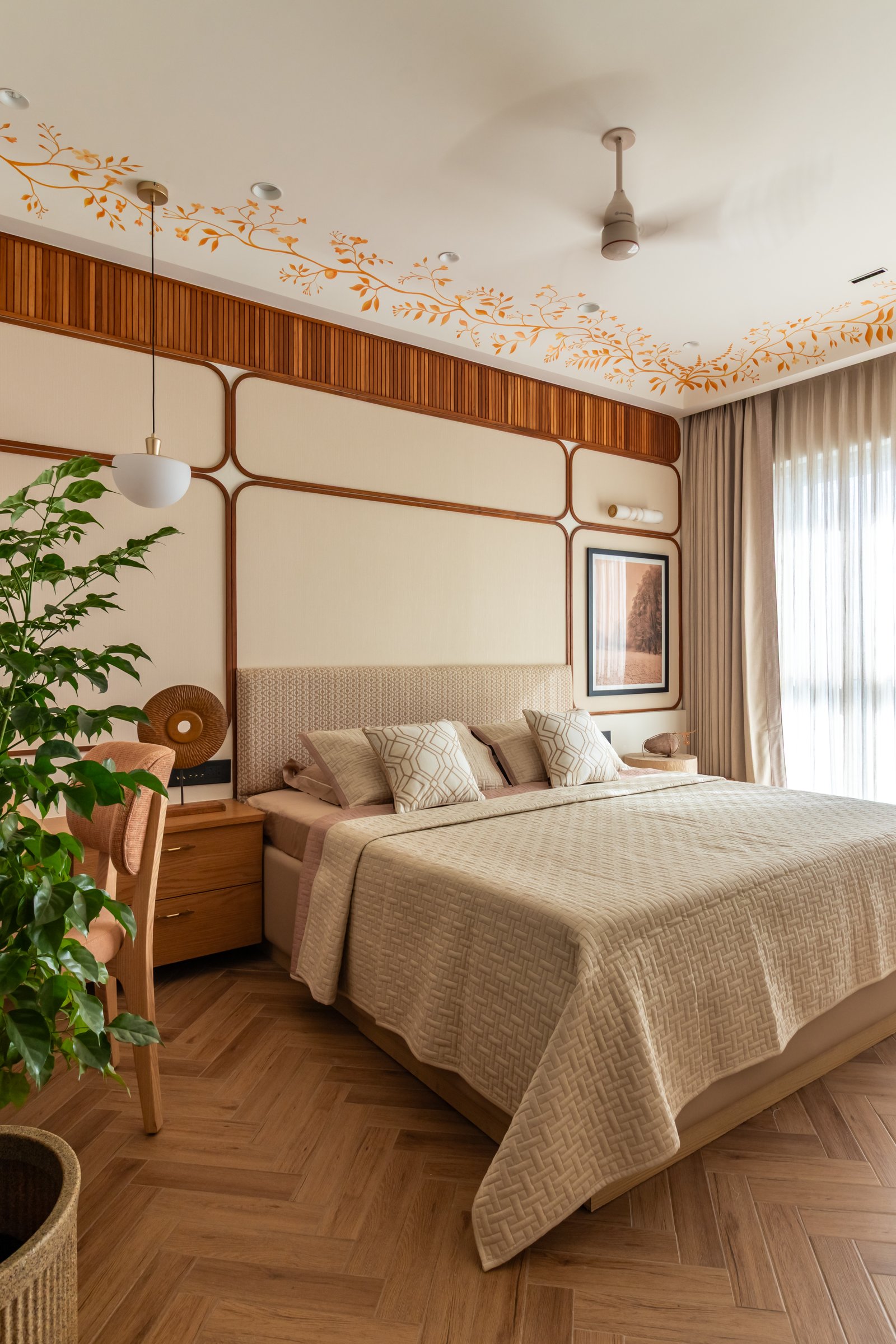 The master bedroom, framed by a grid of rounded timber mouldings and a hand-painted vine motif tracing the ceiling