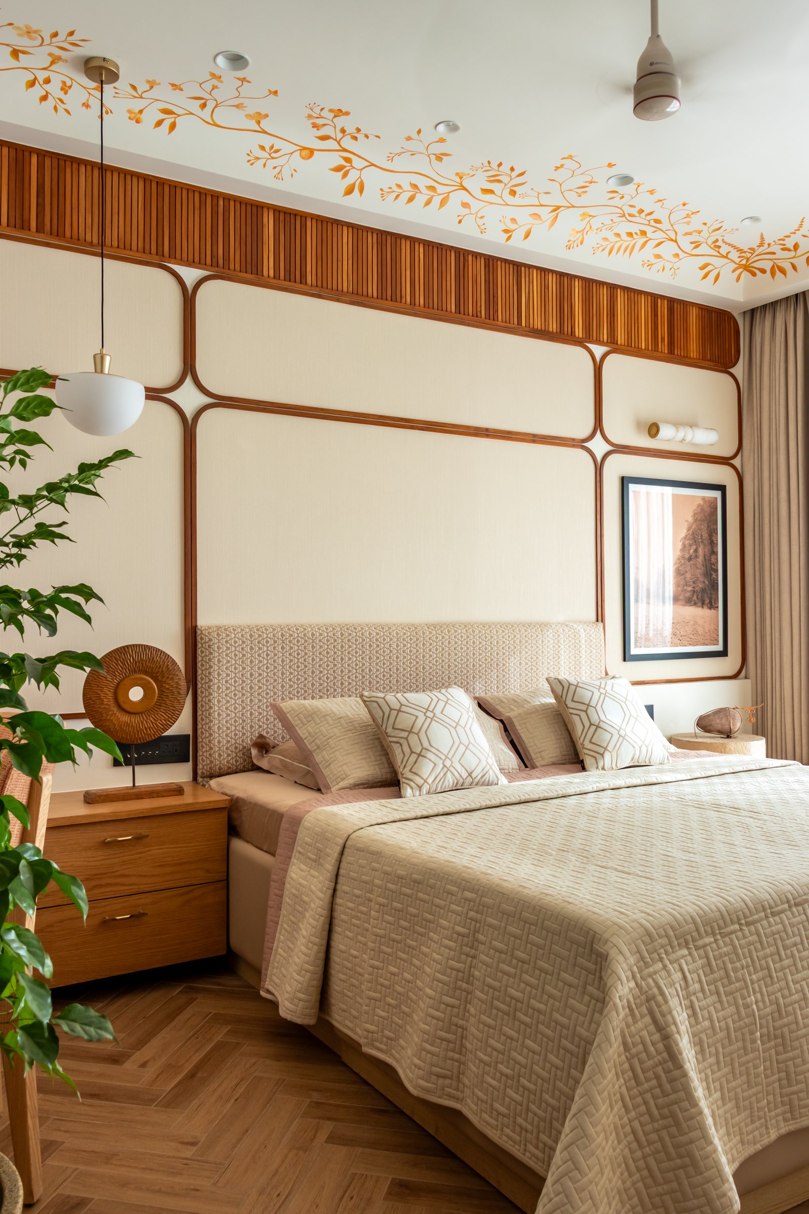 The bed itself dressed in muted beige and blush, with a slim pendant reading light hovering beside it