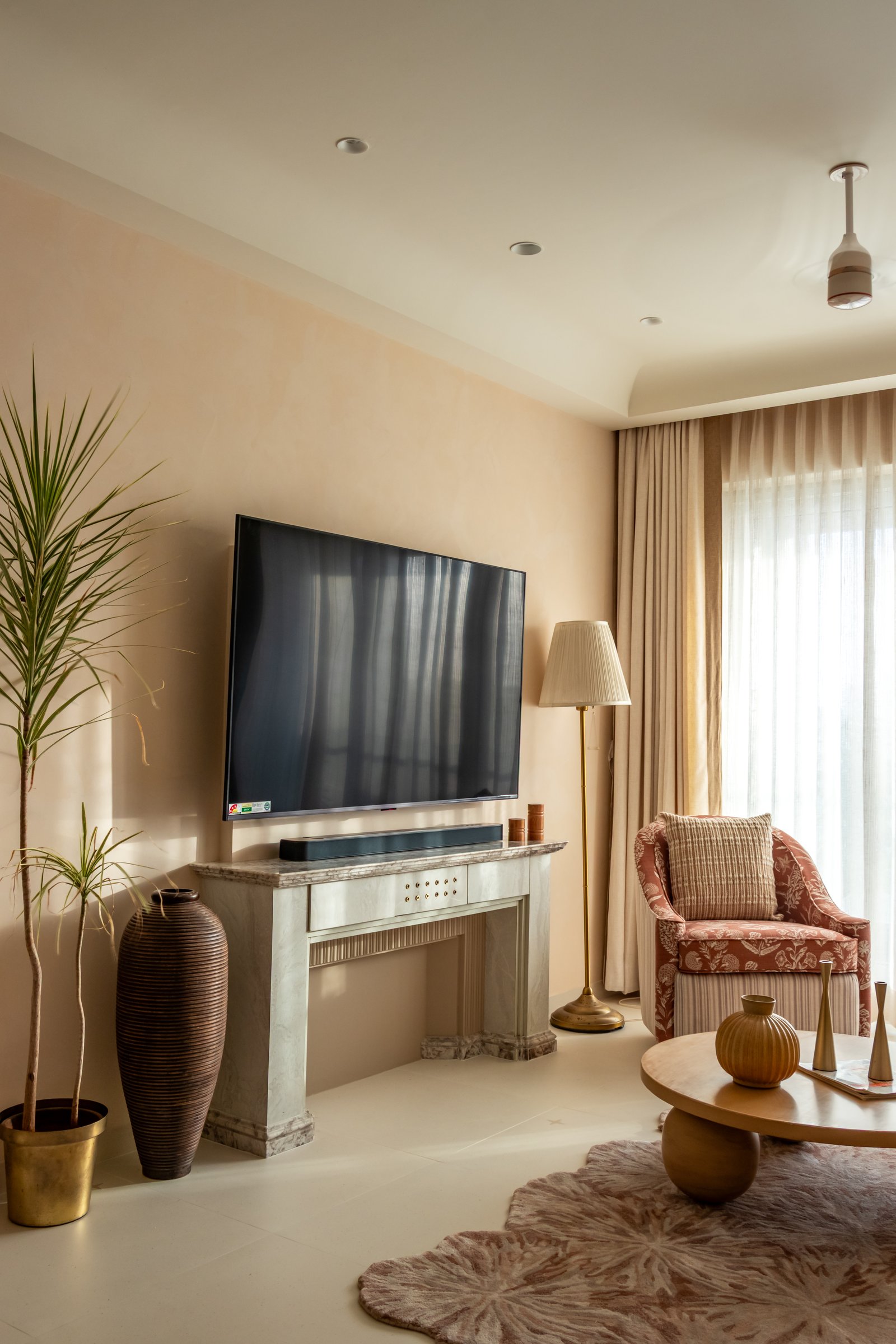 The media wall reinterprets the classical mantelpiece as a veined stone console with fluted detailing