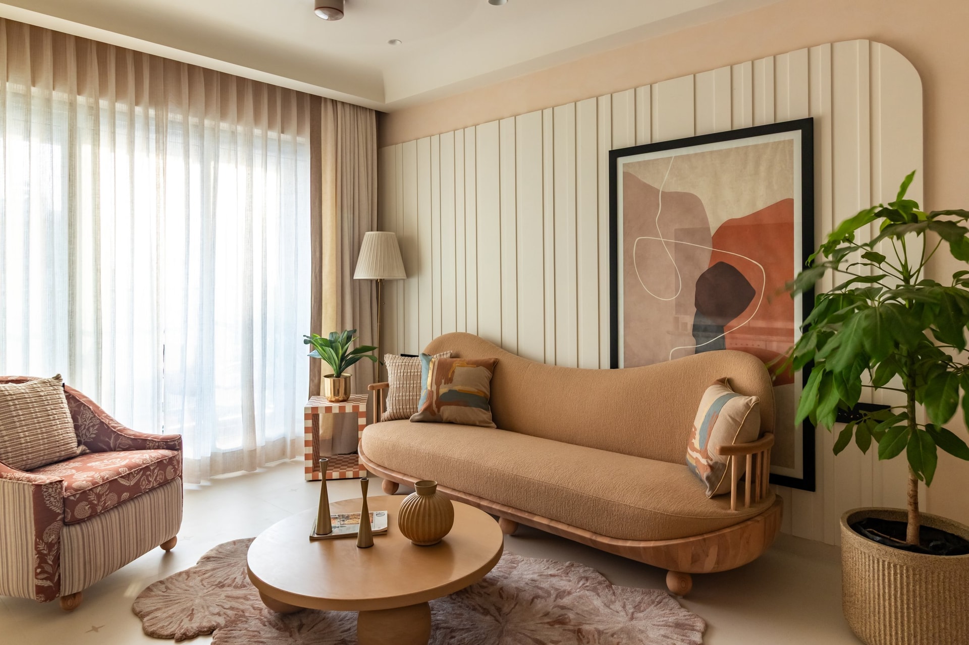 The living room, anchored by a fluted panel wall in warm cream behind an ochre bouclé sofa