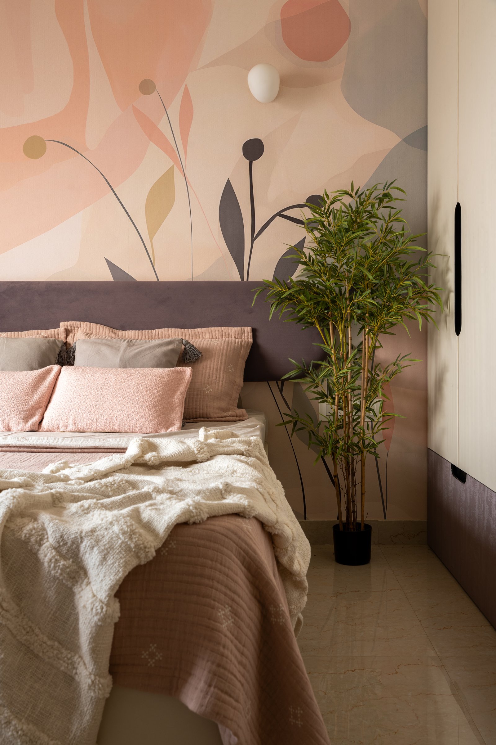 The second child's bedroom, where an abstract mural in peach, blush and grey-brown fills the wall behind the bed