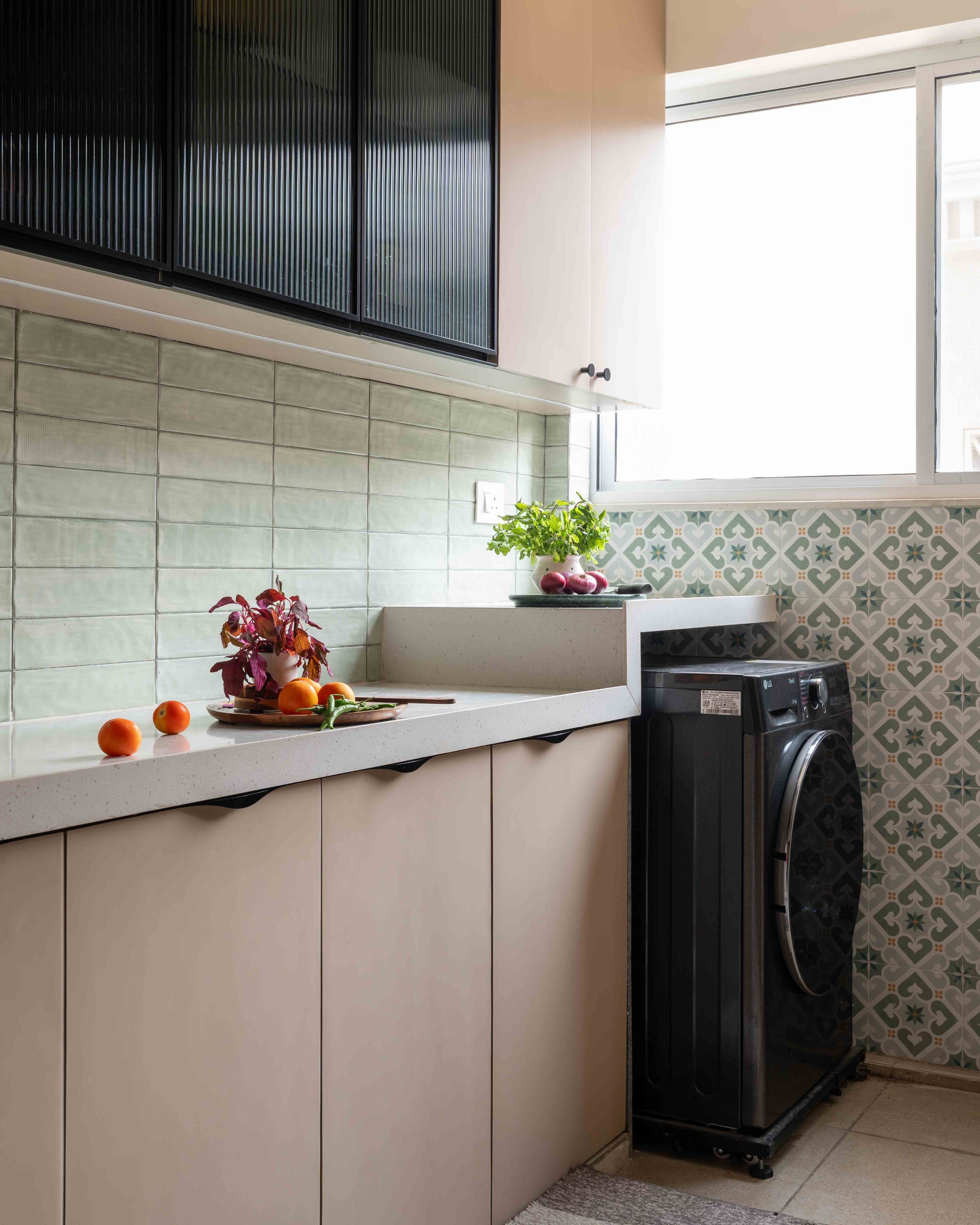 The utility, where a patterned encaustic tile in muted greens meets the plainer field tile of the kitchen