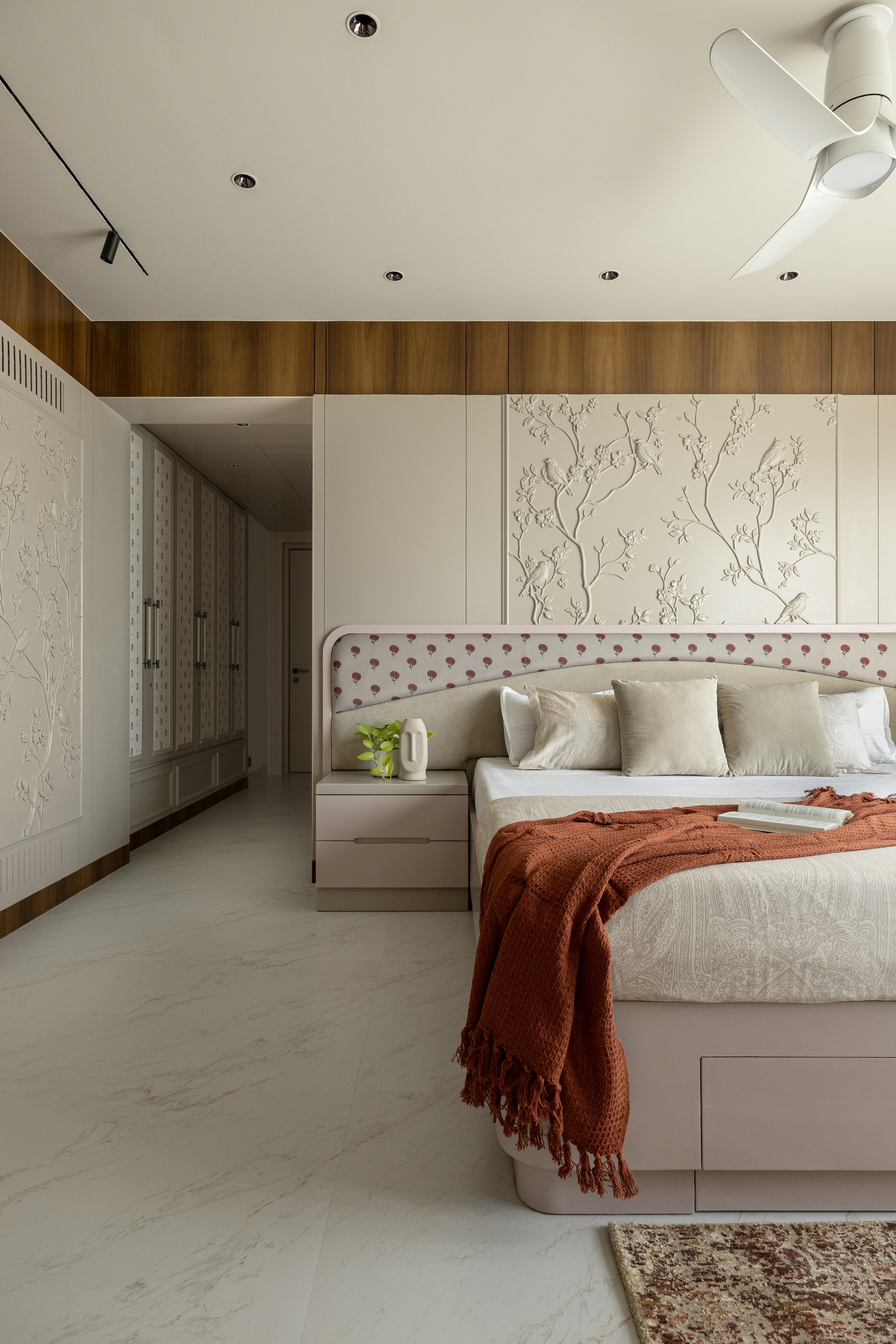 The master suite extends into a dressing passage lined with subtly patterned wardrobes