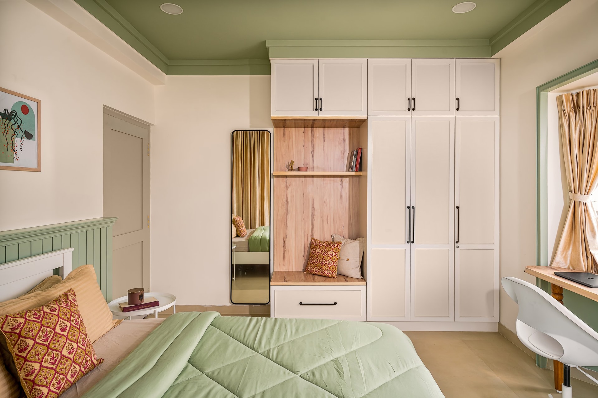 The master bedroom, where sage wainscoting meets a full-height wardrobe run with a central veneered niche