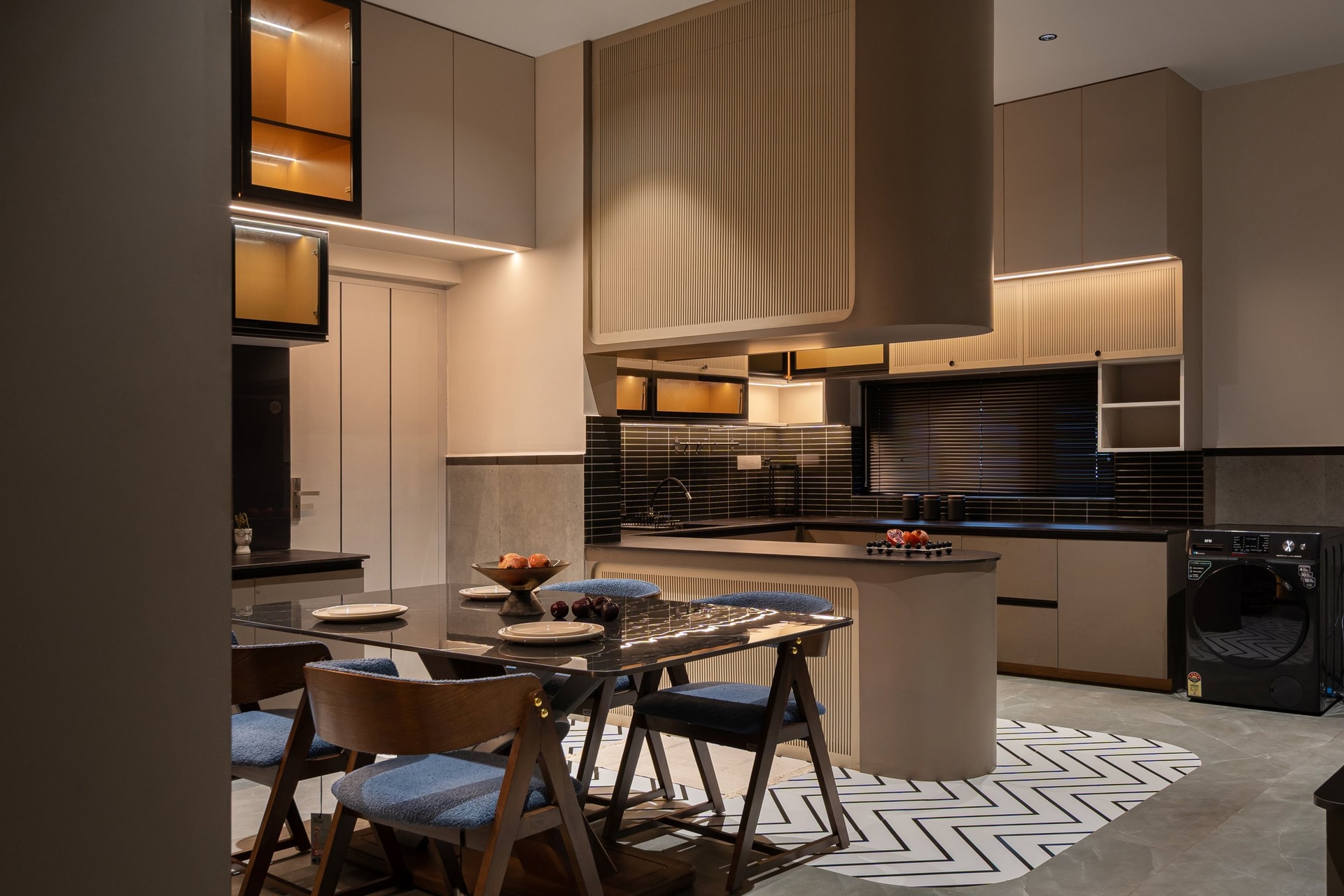 The kitchen, where a sculpted taupe hood drops from the double-height volume above