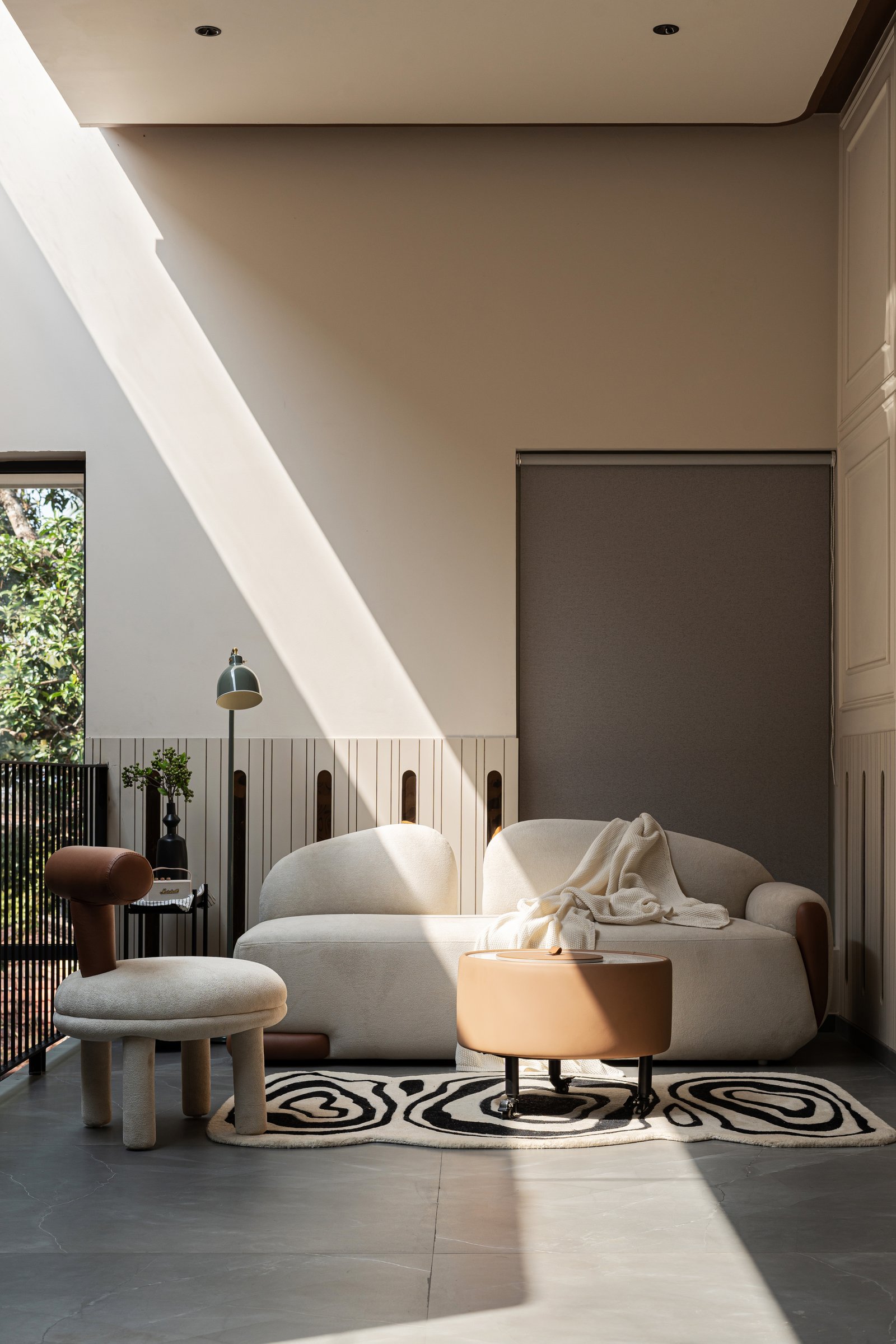 The upper reading corner, catching a diagonal shaft of light across the plastered wall