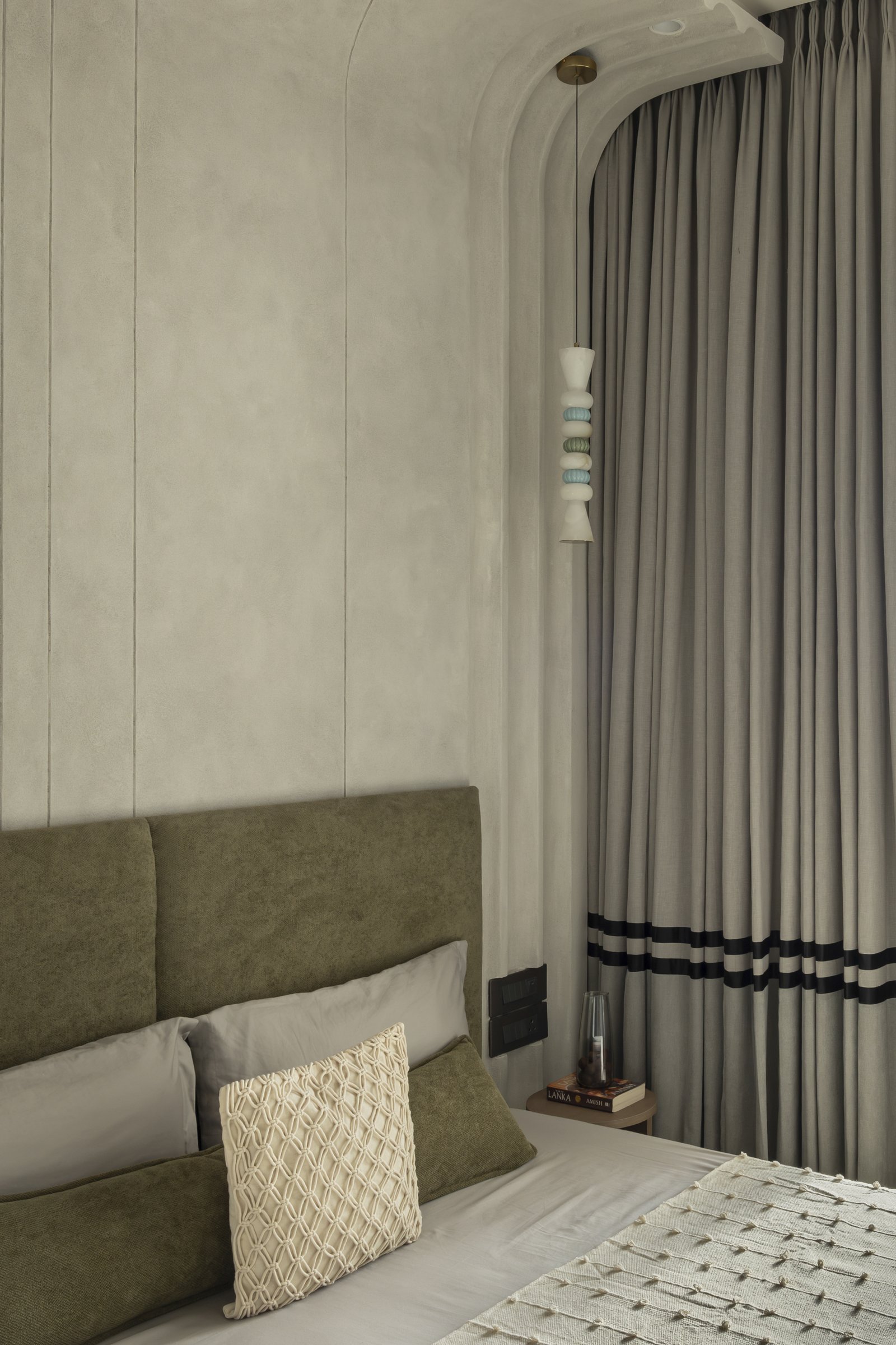 The sculpted beaded pendant hanging beside the room's arched ceiling junction