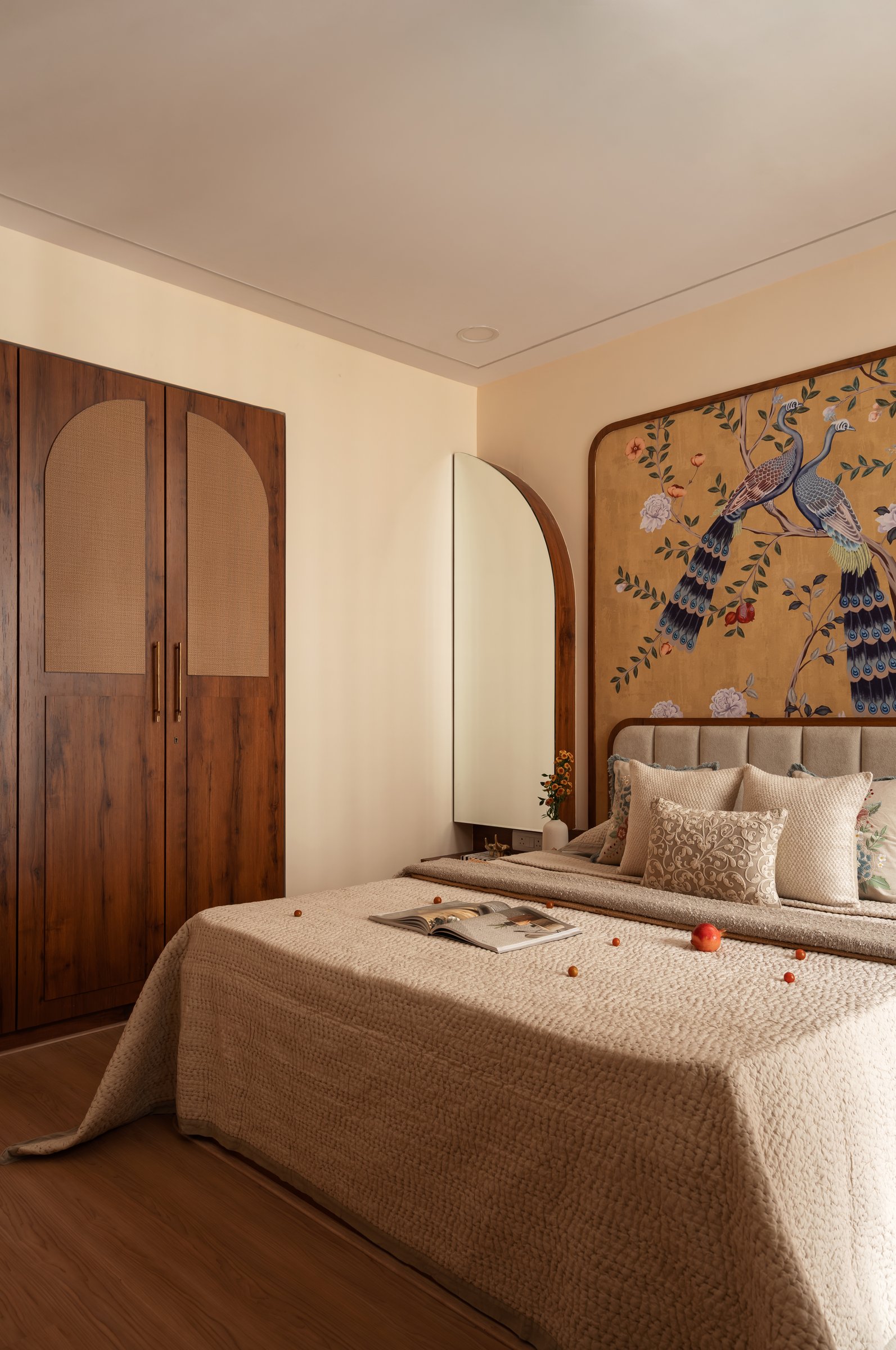 A wider view showing the mural, an arched mirror and a wood-and-cane wardrobe in cohesive dialogue