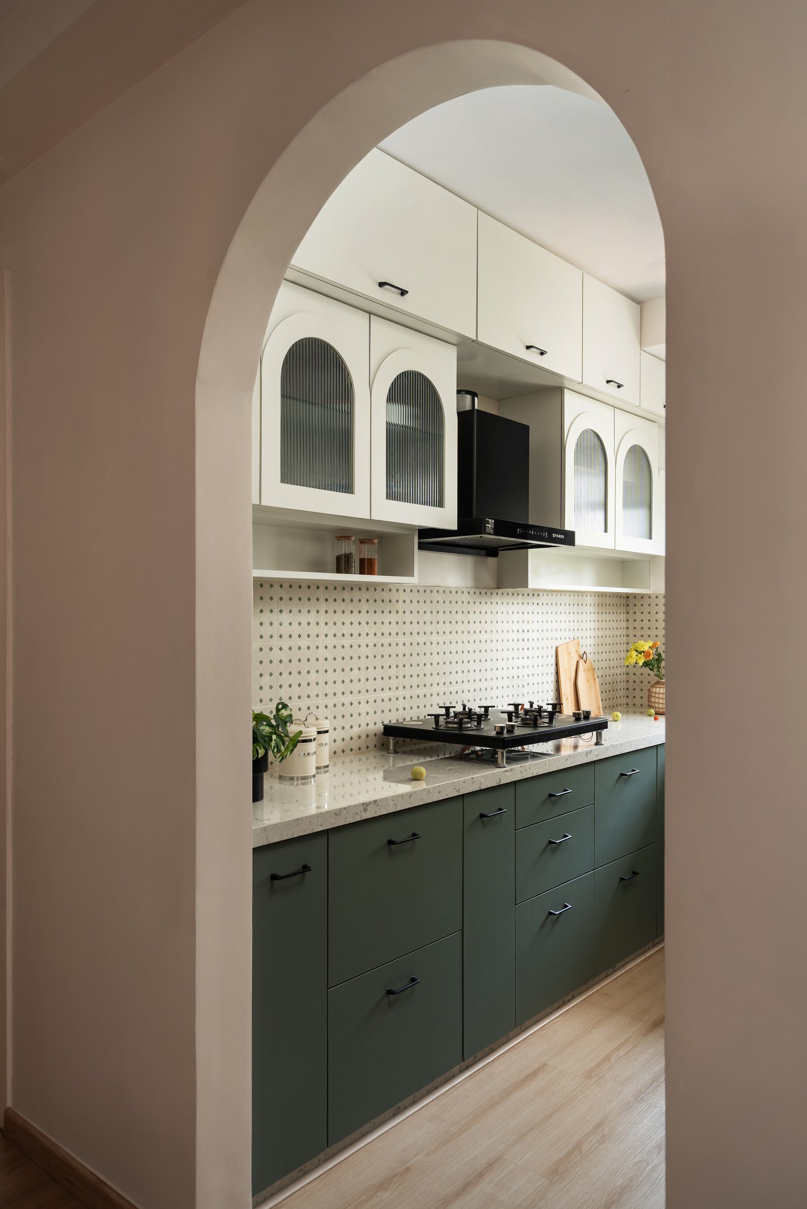 The kitchen seen through a plaster archway that doubles as spatial transition and visual frame