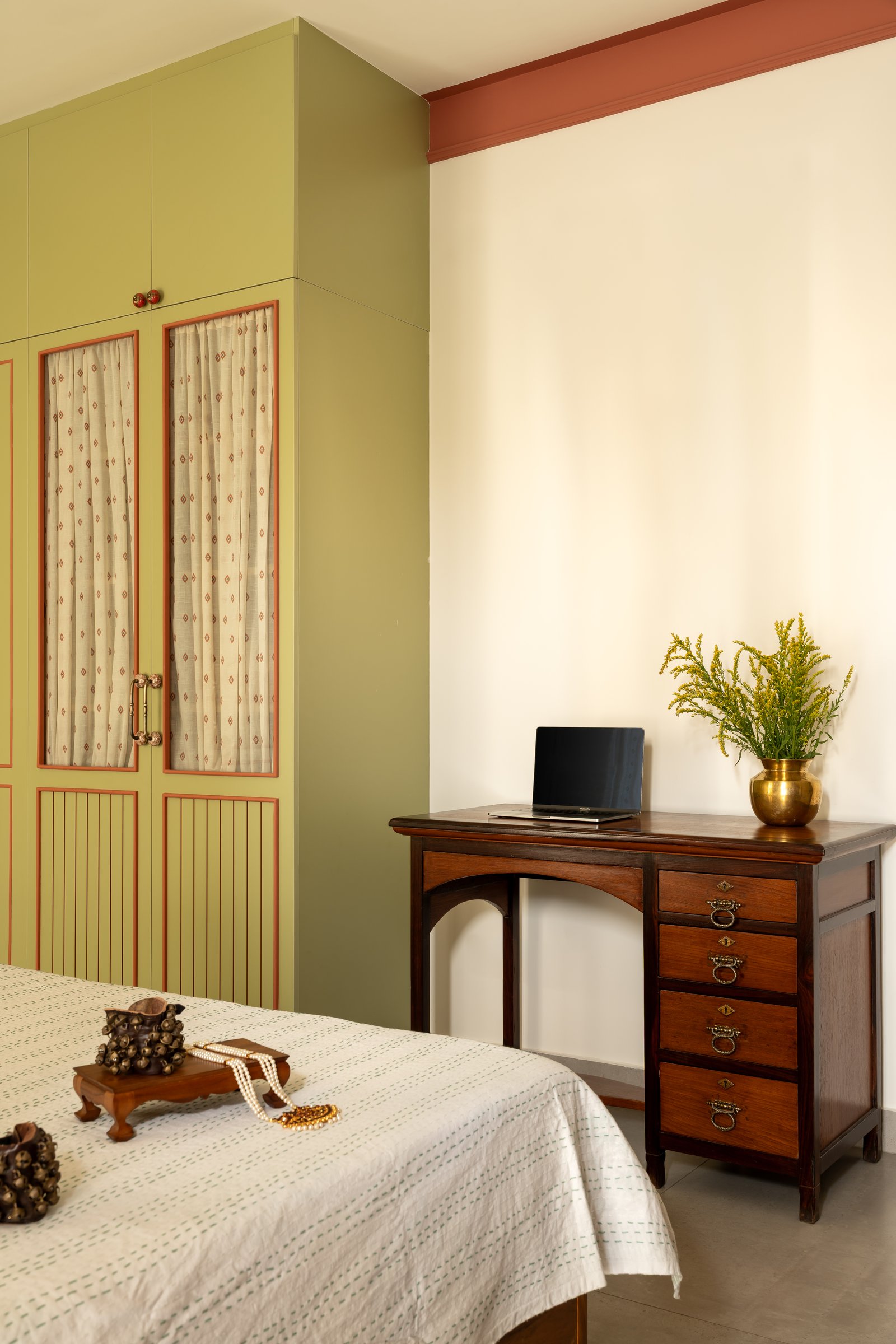 A vintage wooden study table with ring-pull drawers in a quieter corner of the master bedroom