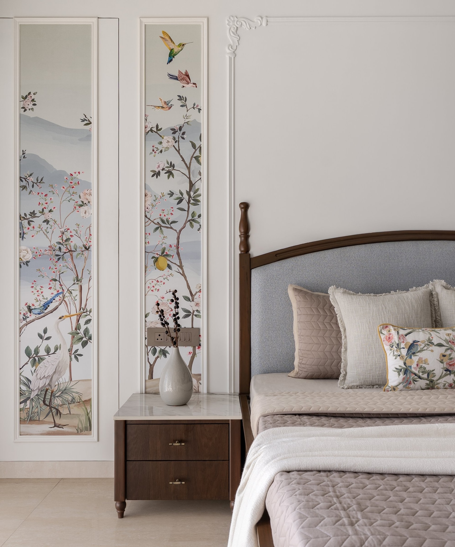 The painterly botanical panels framed as artwork beside the master bed