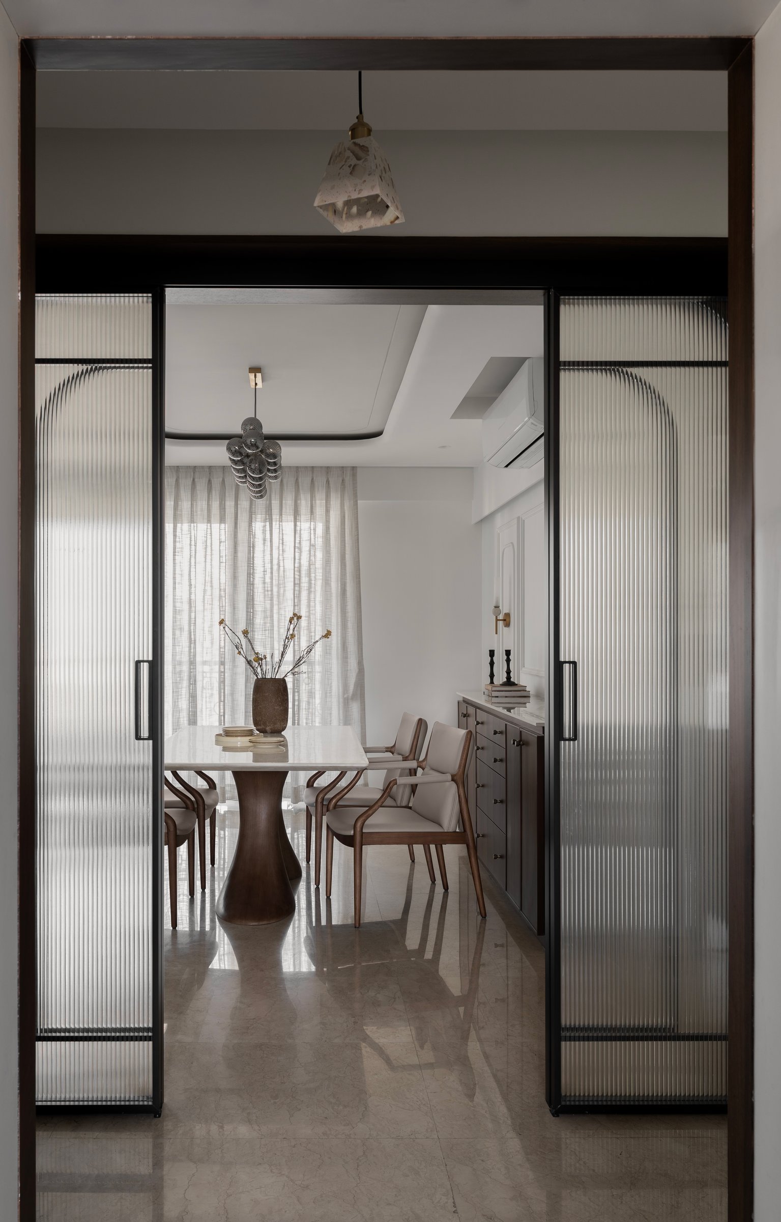 The view from the entry into the dining area, framed by fluted-glass sliding doors