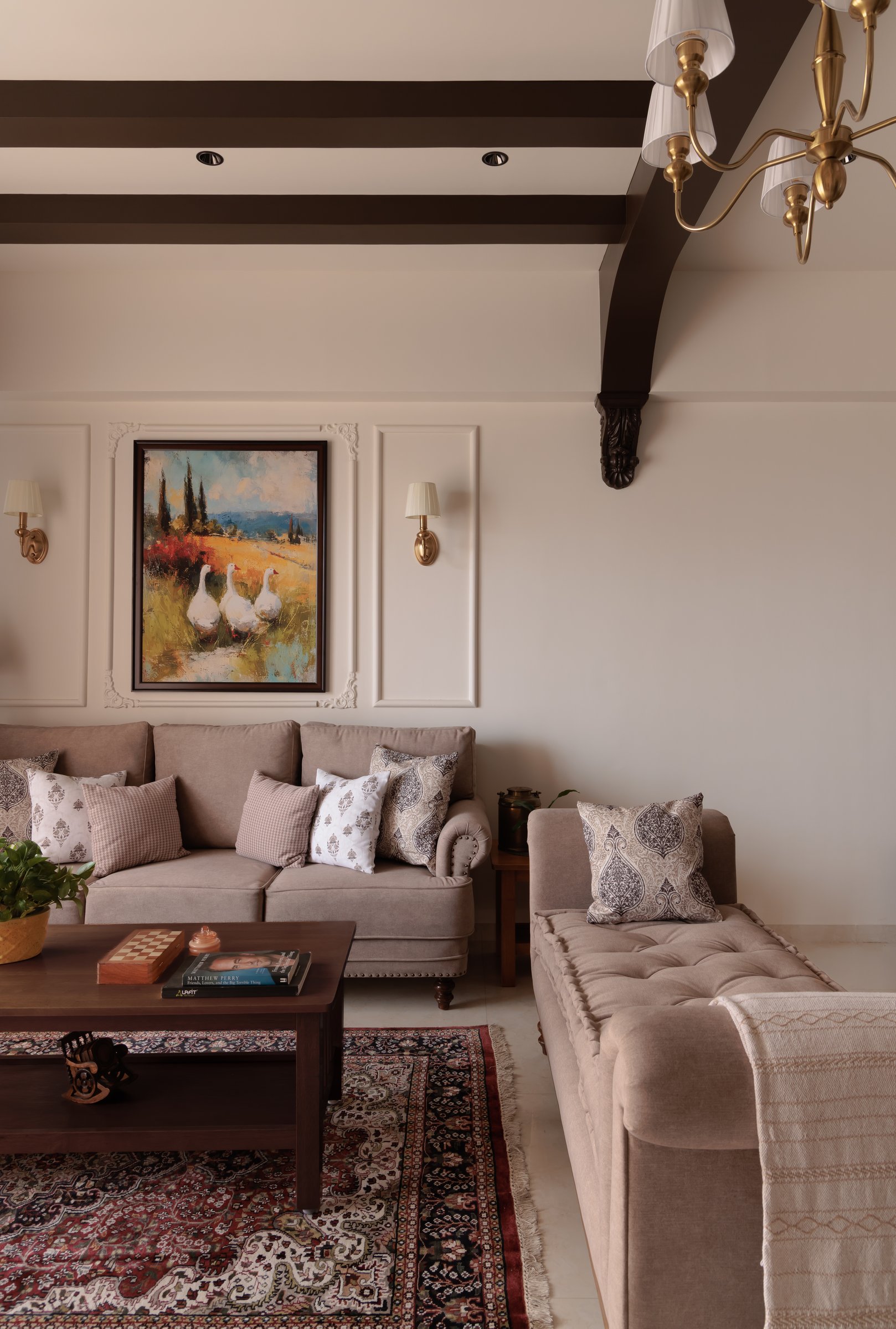 A closer view of the panelled wall and corbel detail, where a landscape painting is framed between brass sconces