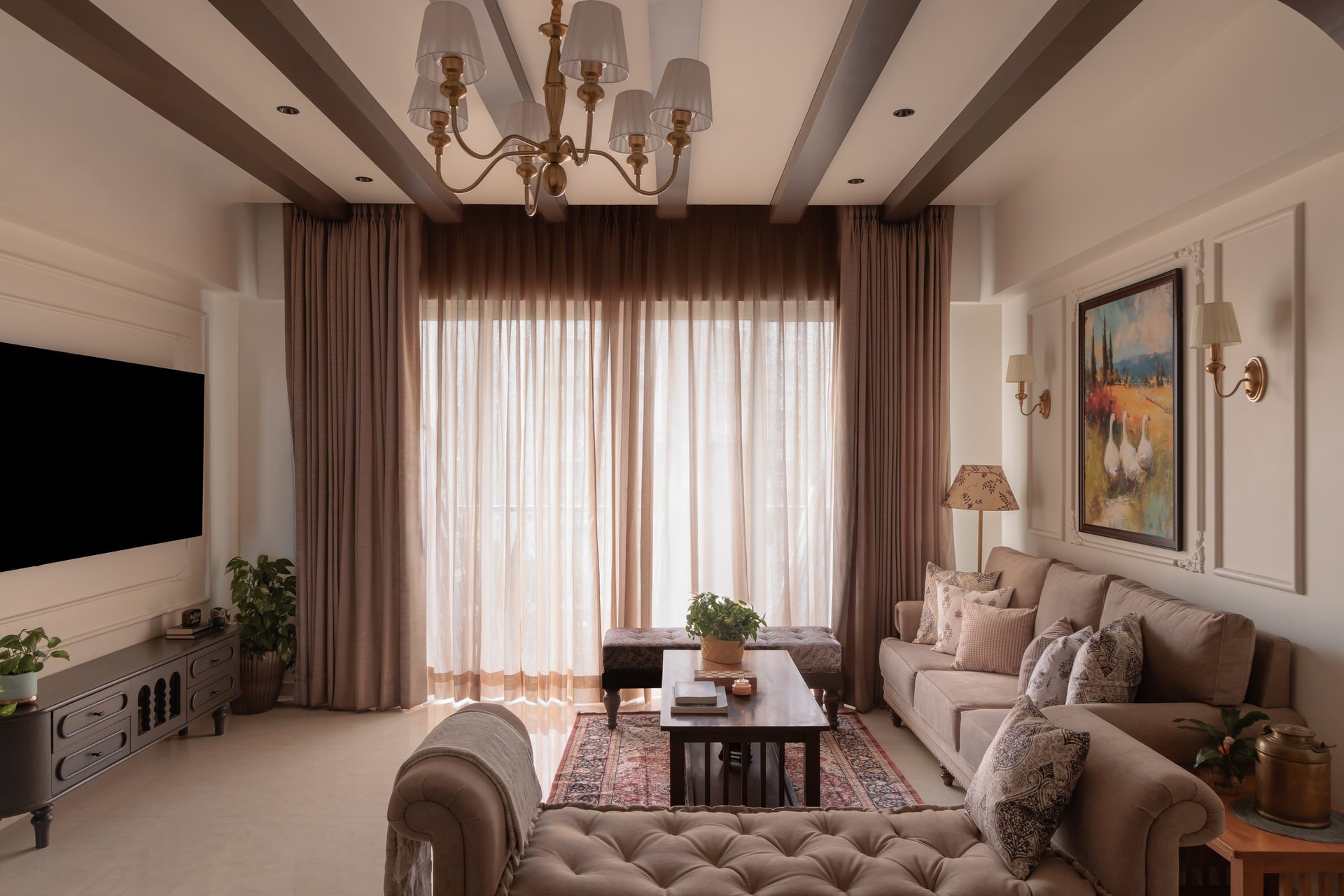 The living room, where panelled ivory walls, dark wooden beams and a brass chandelier set the home's English register