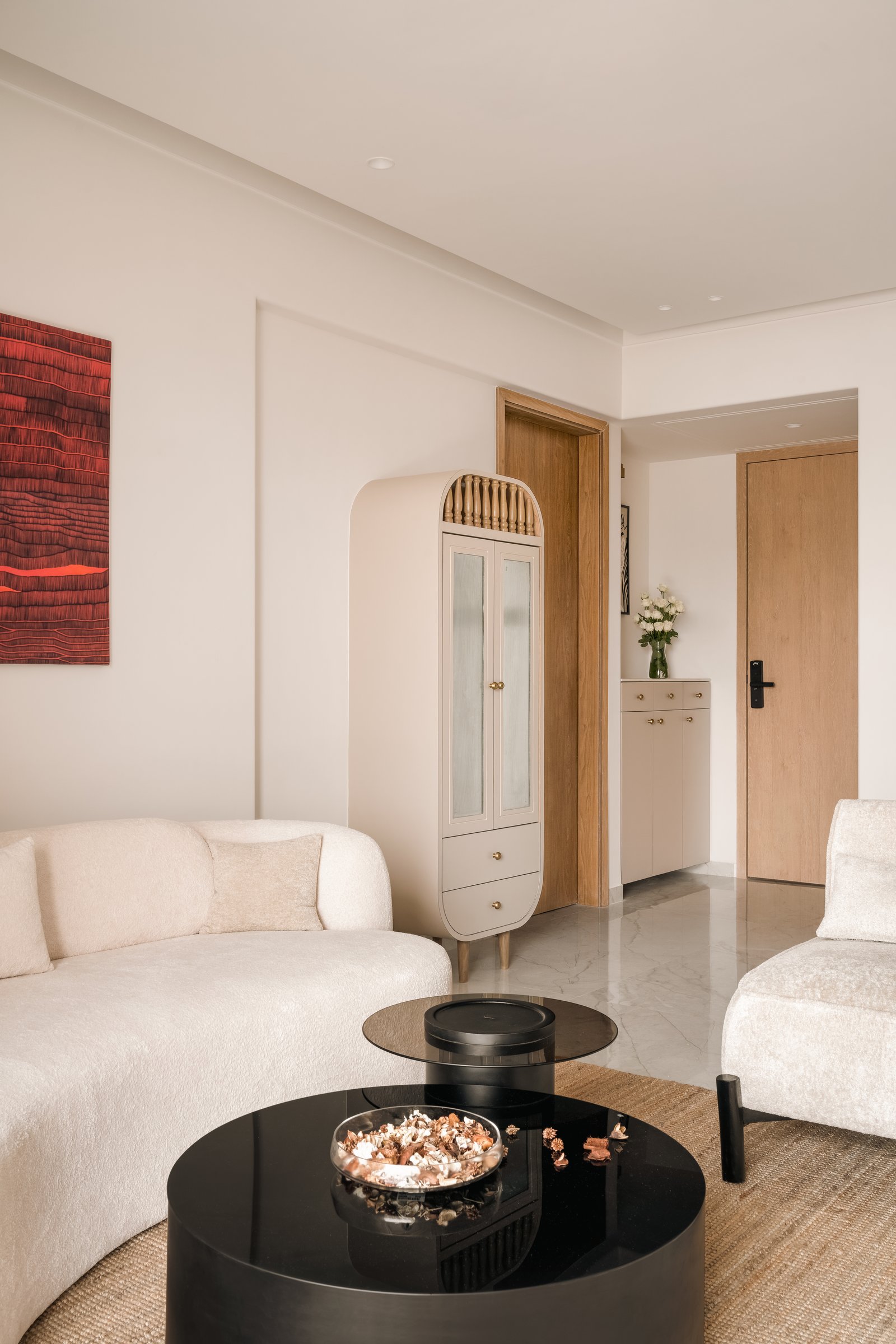 Looking back toward the entry, where a slender fluted wardrobe marks the transition between the social zone and the private quarters