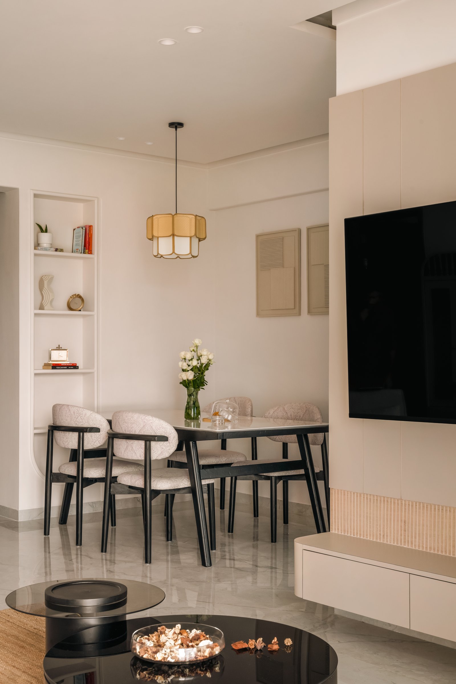 The dining area, where a cane pendant and textured wall panels establish a quiet handcrafted rhythm
