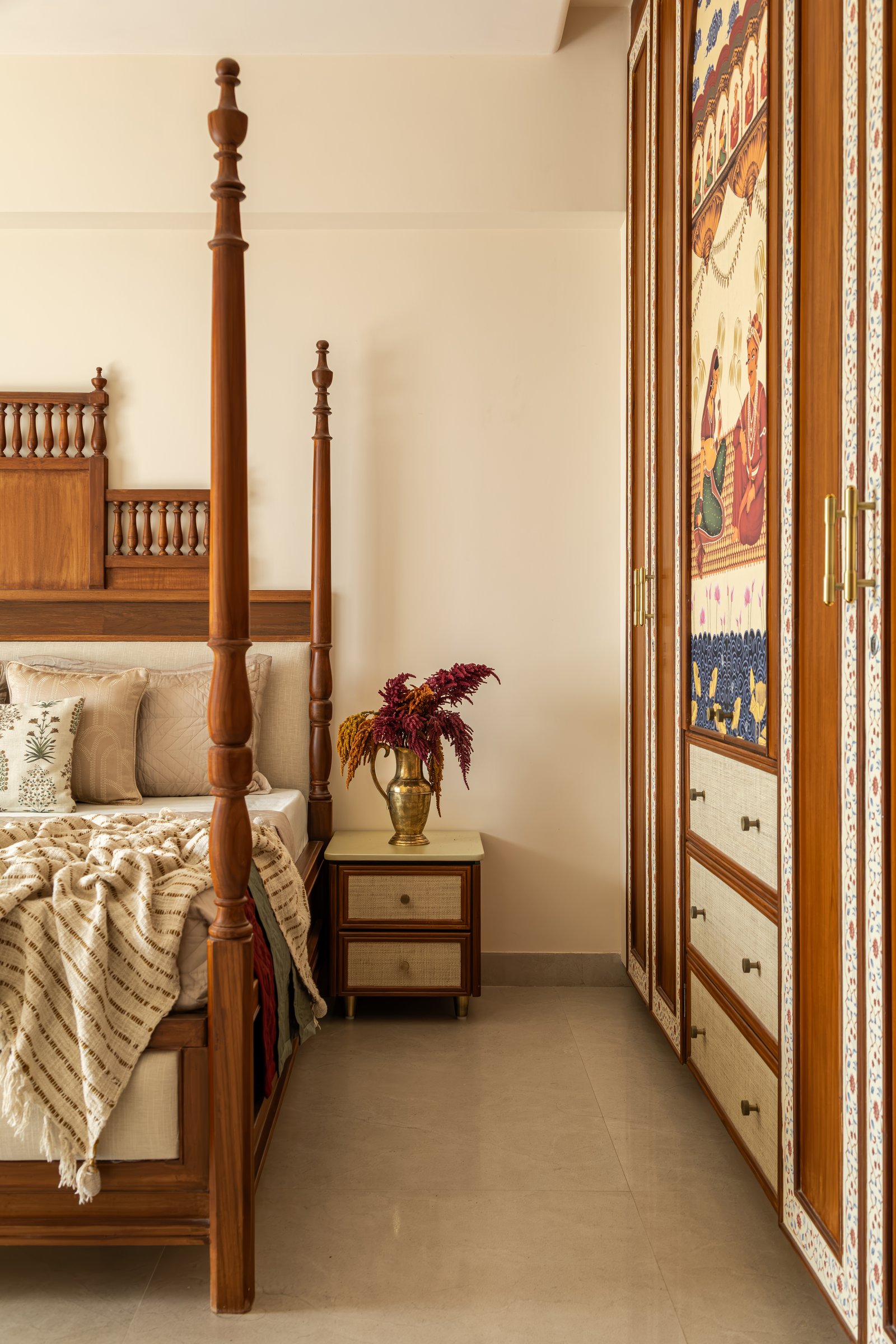 A side view of the primary bedroom, where a hand-painted wardrobe panel sits in dialogue with the four-poster across the room