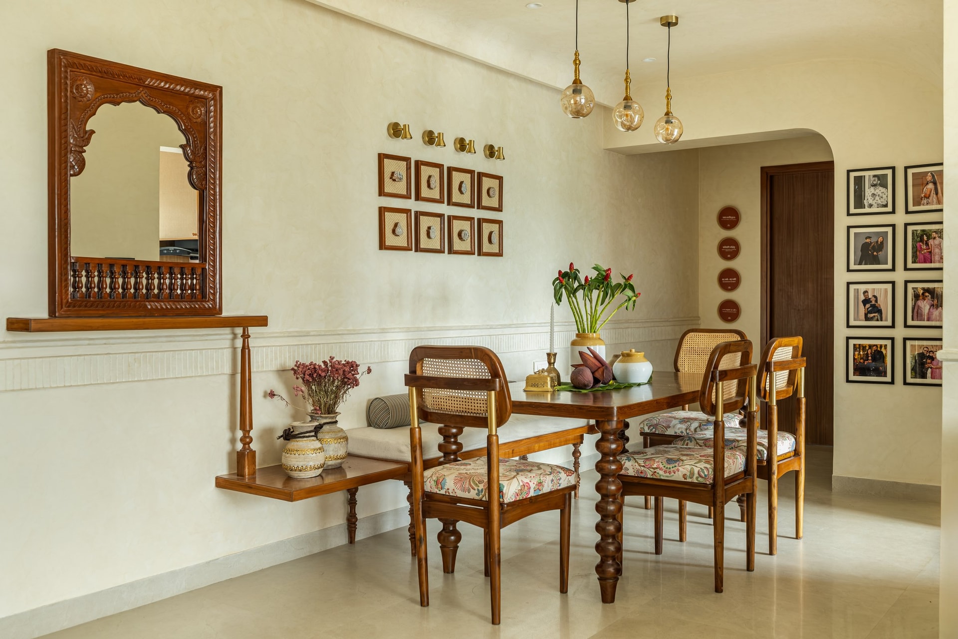 A wider view of the dining room, where a carved wooden mirror and wall-mounted bench extend the room's craft vocabulary
