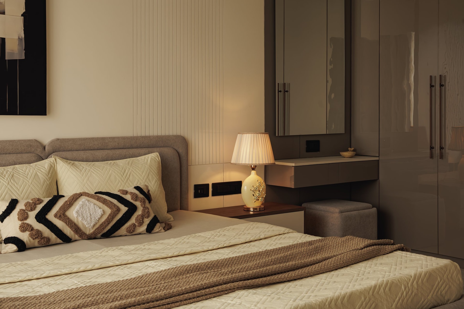 The storage wall of the second bedroom, where high-gloss taupe wardrobes meet a floating desk-console