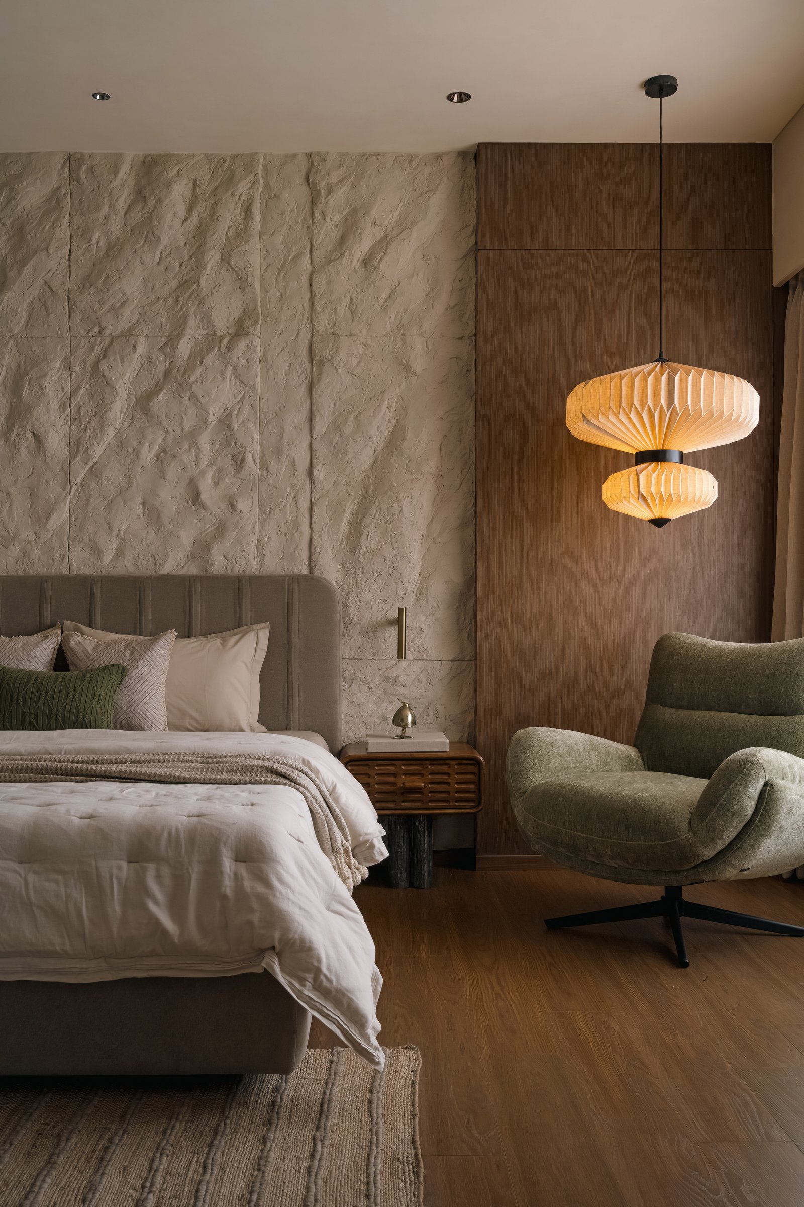 The primary bedroom, where a hand-sculpted plaster wall meets warm veneered joinery