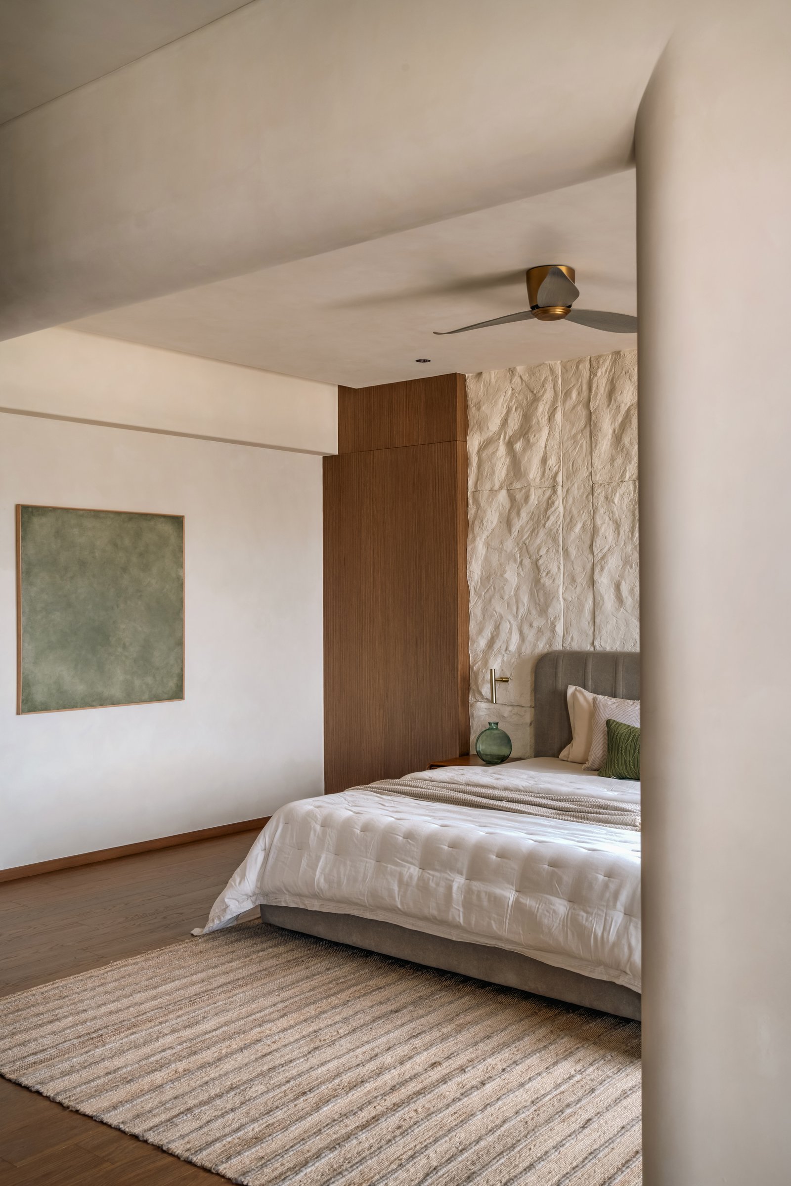 The bedroom from the dressing area, with curved structural edges softening the geometry
