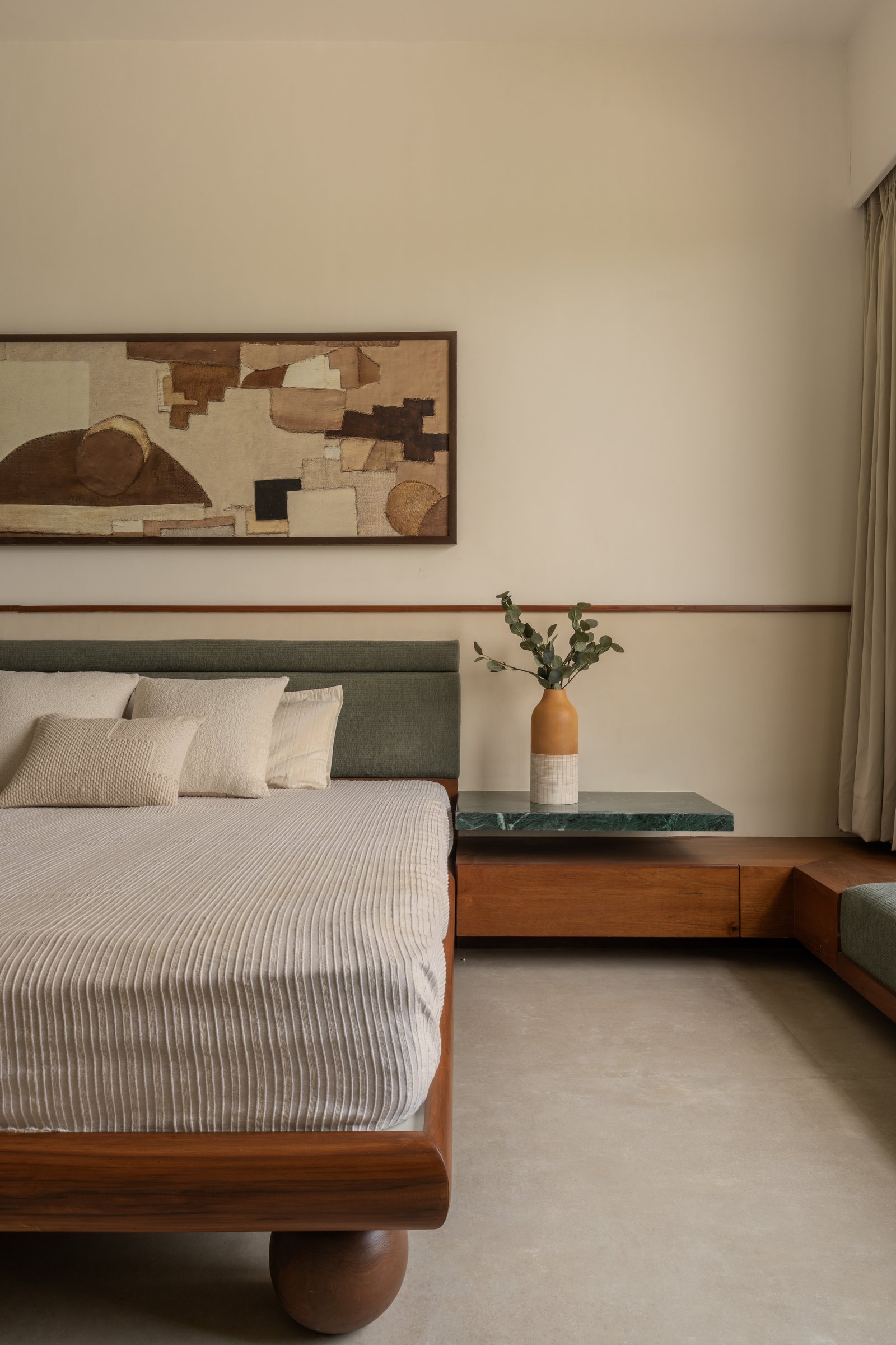 The bed's rounded wooden base meets a dark-stone-topped ledge that extends into a window seat