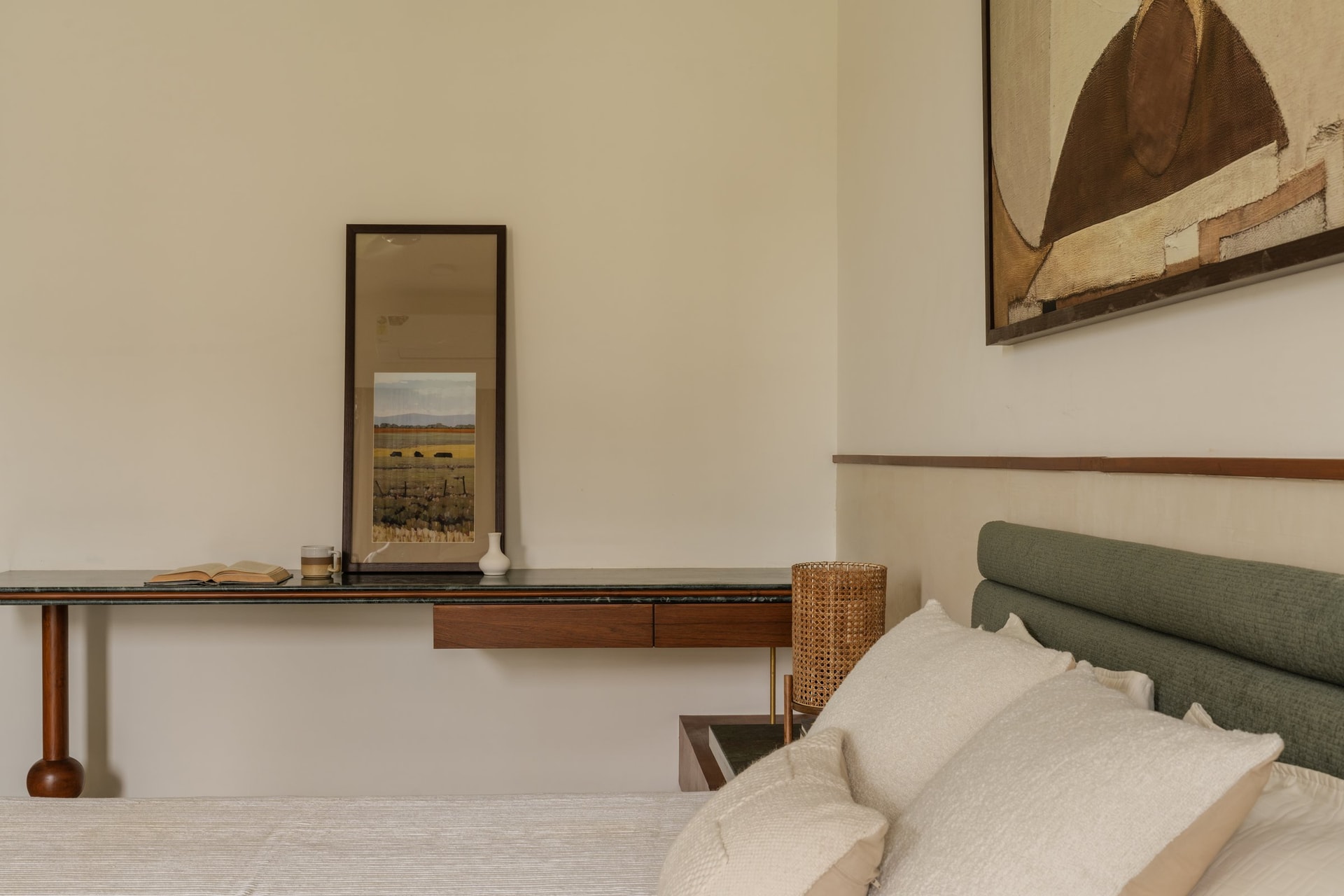 A floating wooden desk with a dark stone top, anchored by a single turned leg